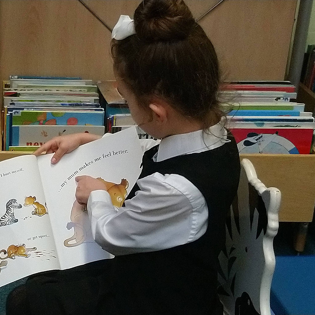 Child in a uniform reading a book
